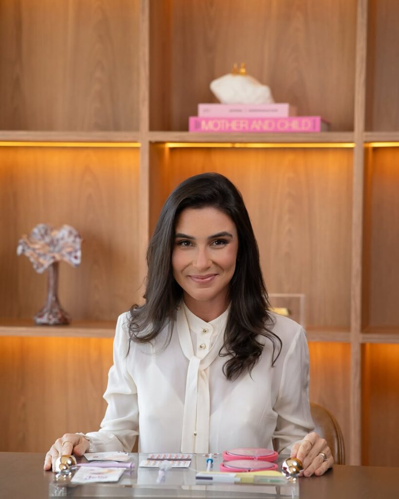 Dra Mariana mostrando diversos métodos contraceptivos em seu consultório.